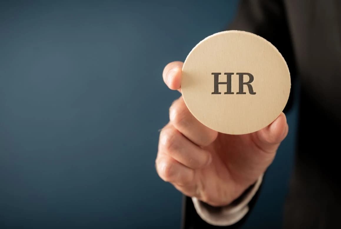 Hand holding a wooden HR token